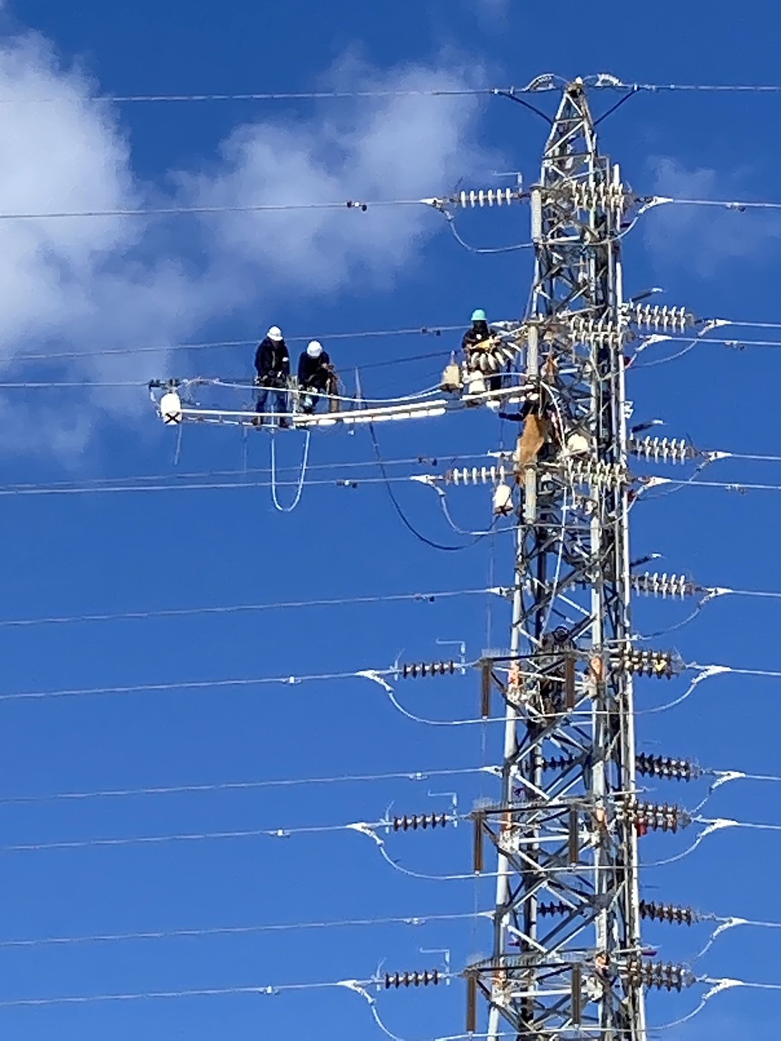 送電鉄塔で作業を行う電気工事士 高所電気工事 点検・補修